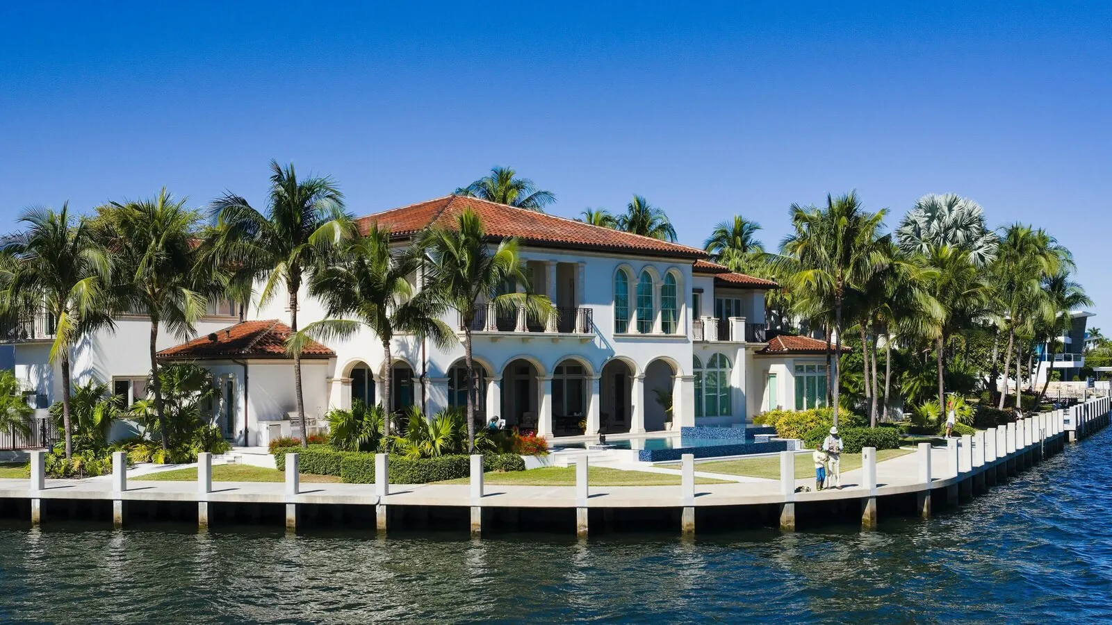 Waterfront home framed by palm trees